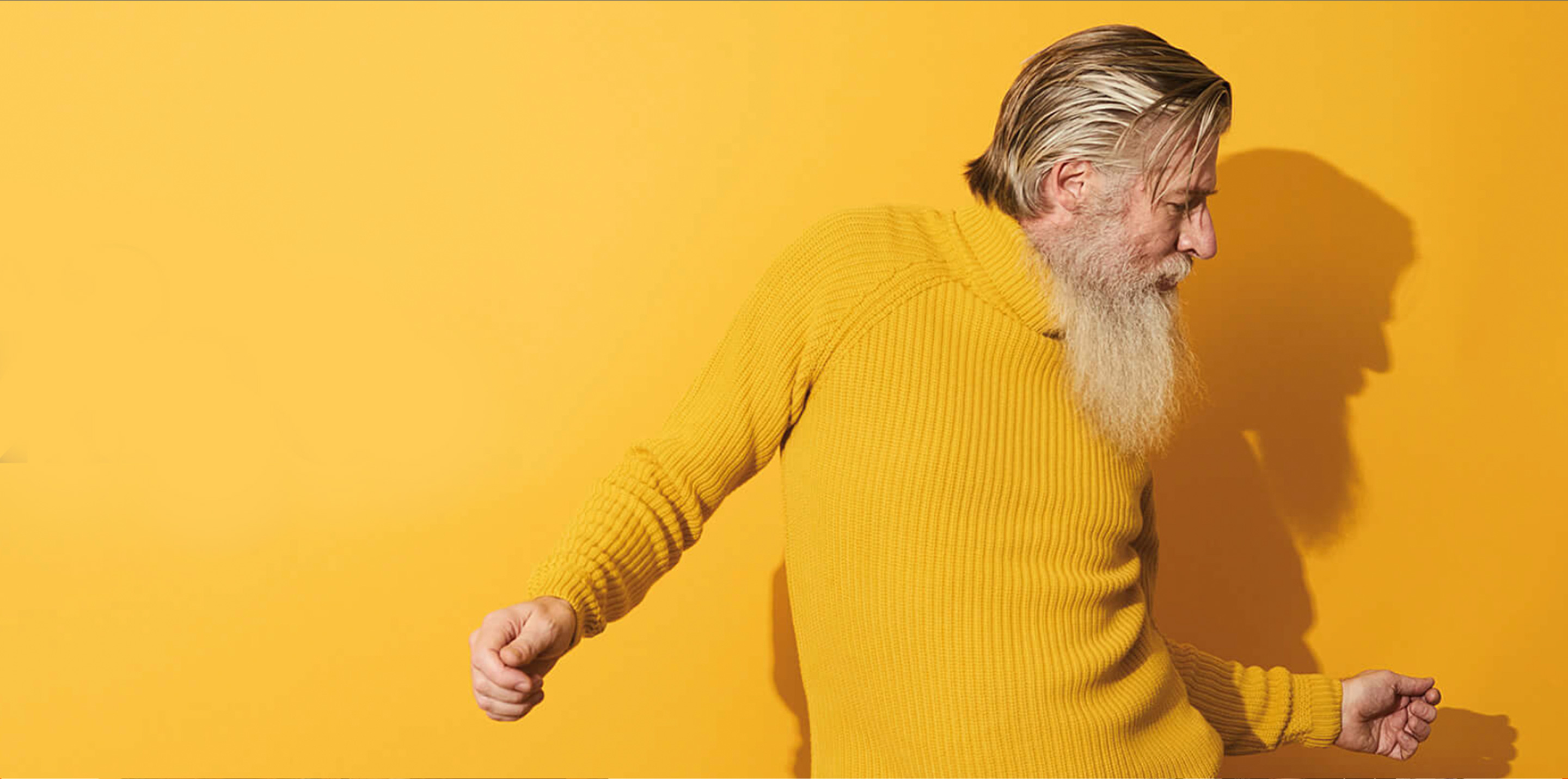 Man in yellow jumper looking happy