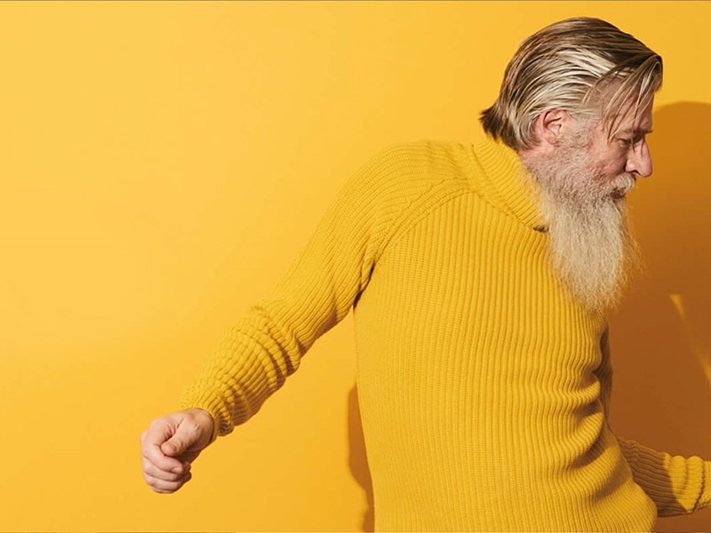 Man in yellow jumper looking happy